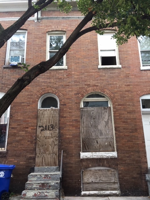 2113 McCulloh Street before rehabilitation — boarded windows and deteriorated facade, Druid Heights Baltimore